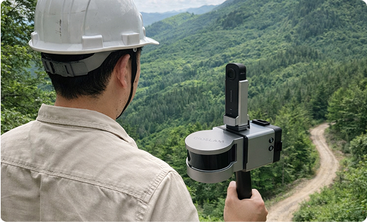 측량 장비로 산림 지형을 조사하는 장면